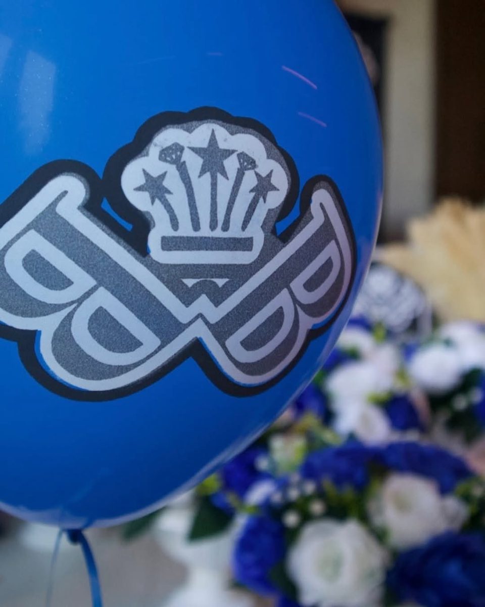 A Baller Bossez balloon over blue and white flowers